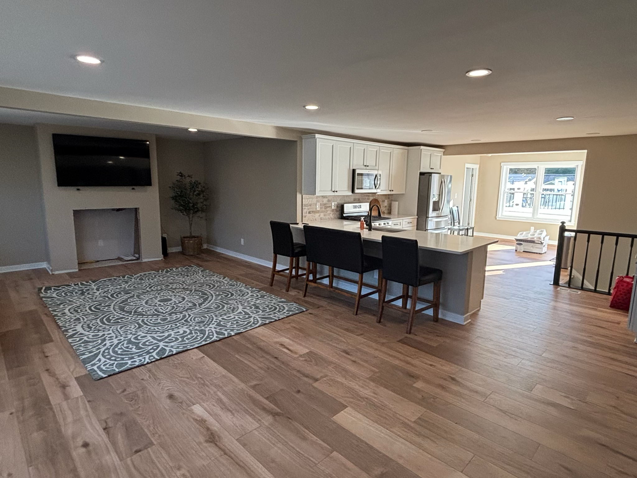 Open-concept living space addition with hardwood floors by Dynamic Remodeling